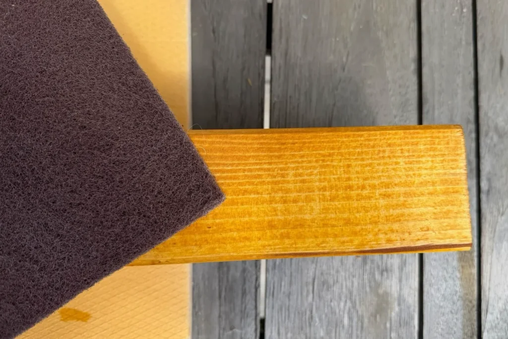 Getrocknetes lasiertes Holz wird mit Schleifvlies geglättet