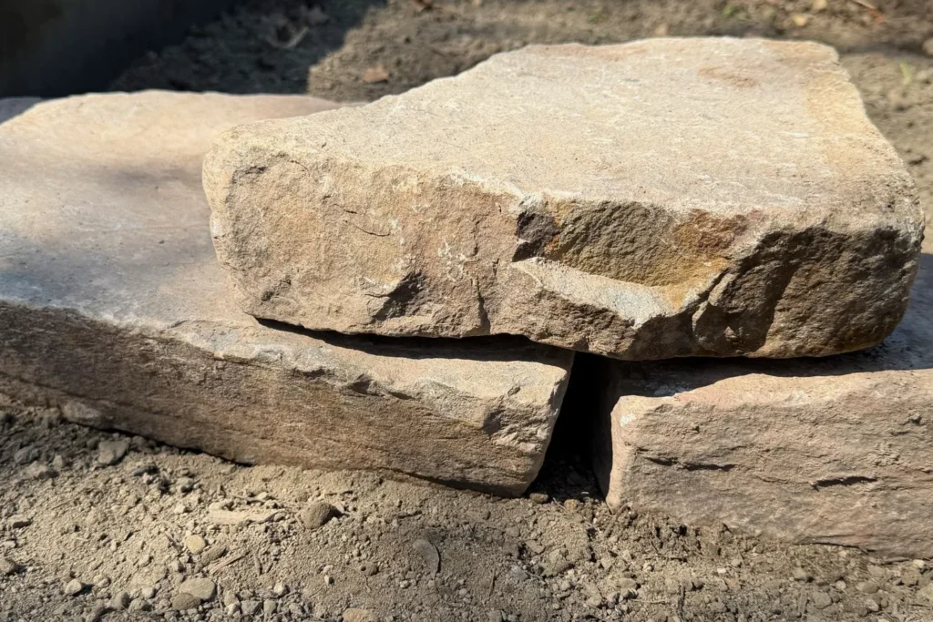 Nahaufnahme einer kleinen Trockenmauer aus aufgeschichteten Natursteinen mit Fugen und Hohlräumen