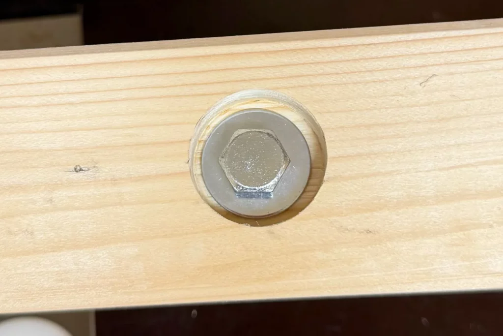 Bündig versenkter Schraubenkopf in einer Senkbohrung im Holz.