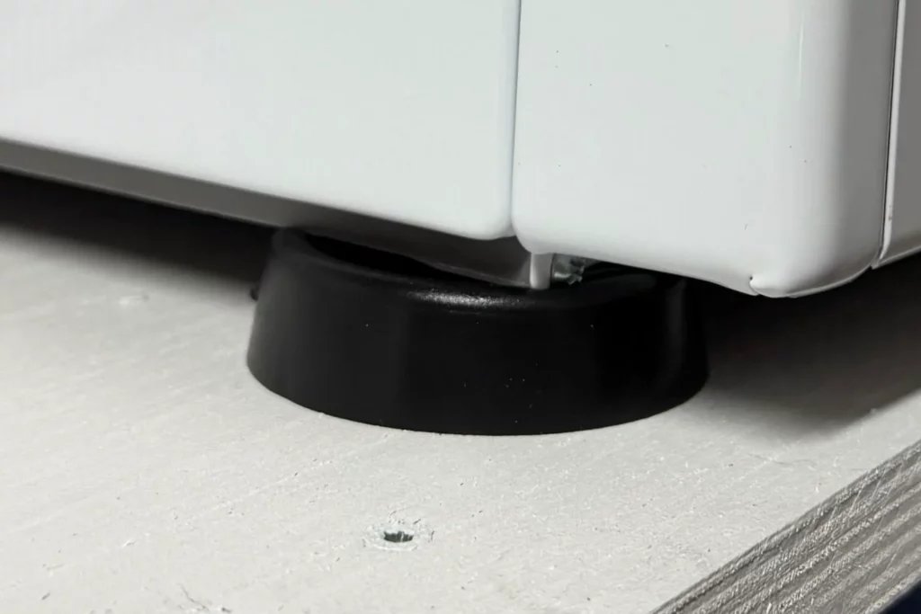 Gummi-Schwingungsdämpfer unter dem Standfuß einer Waschmaschine.