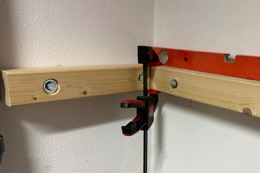 Zweiter Wandbalken wird mit Schraubzwinge und Wasserwaage ausgerichtet.
