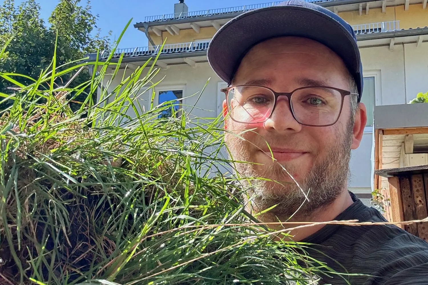 Mann zeigt eine ausgestochene Grasnarbe für die erste Füllschicht