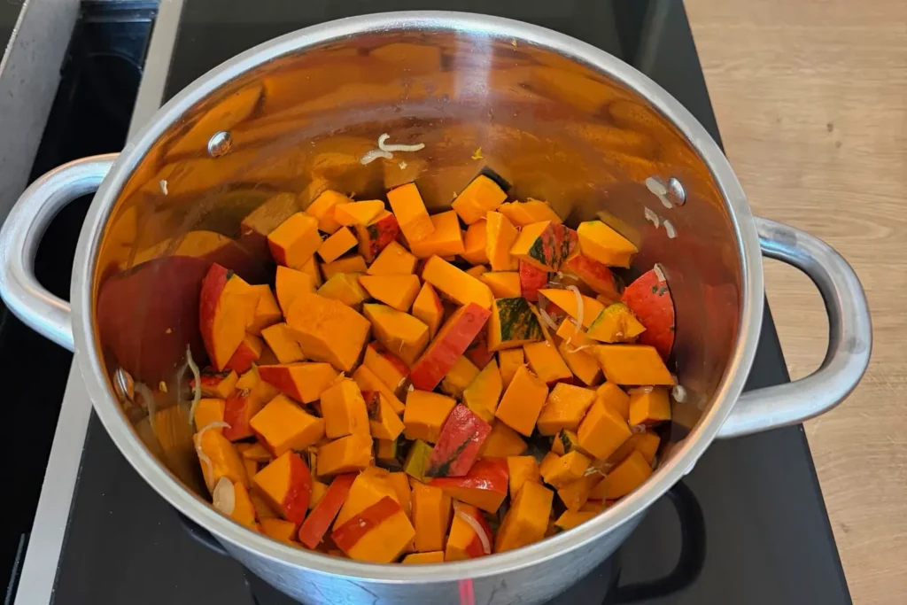 Hokkaido-Würfel dünsten mit Schalotten im Kochtopf